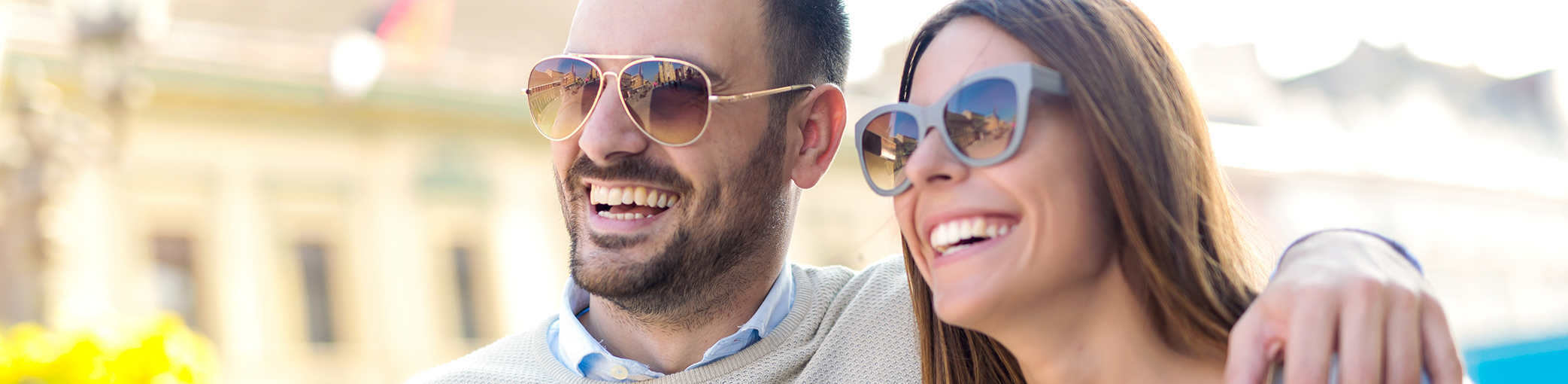 Man and woman smiling with sunglasses on