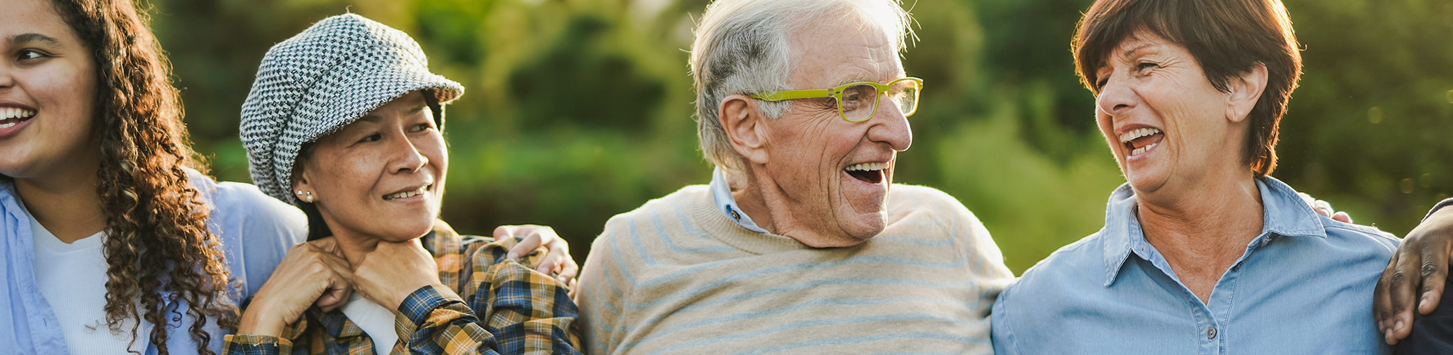 Three seniors laughing outdoors after receiving dental services in Bullard