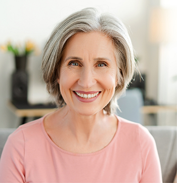 Smiling senior woman in a light pink blouse